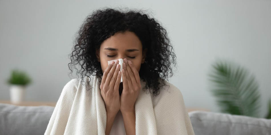 A woman blows her nose.